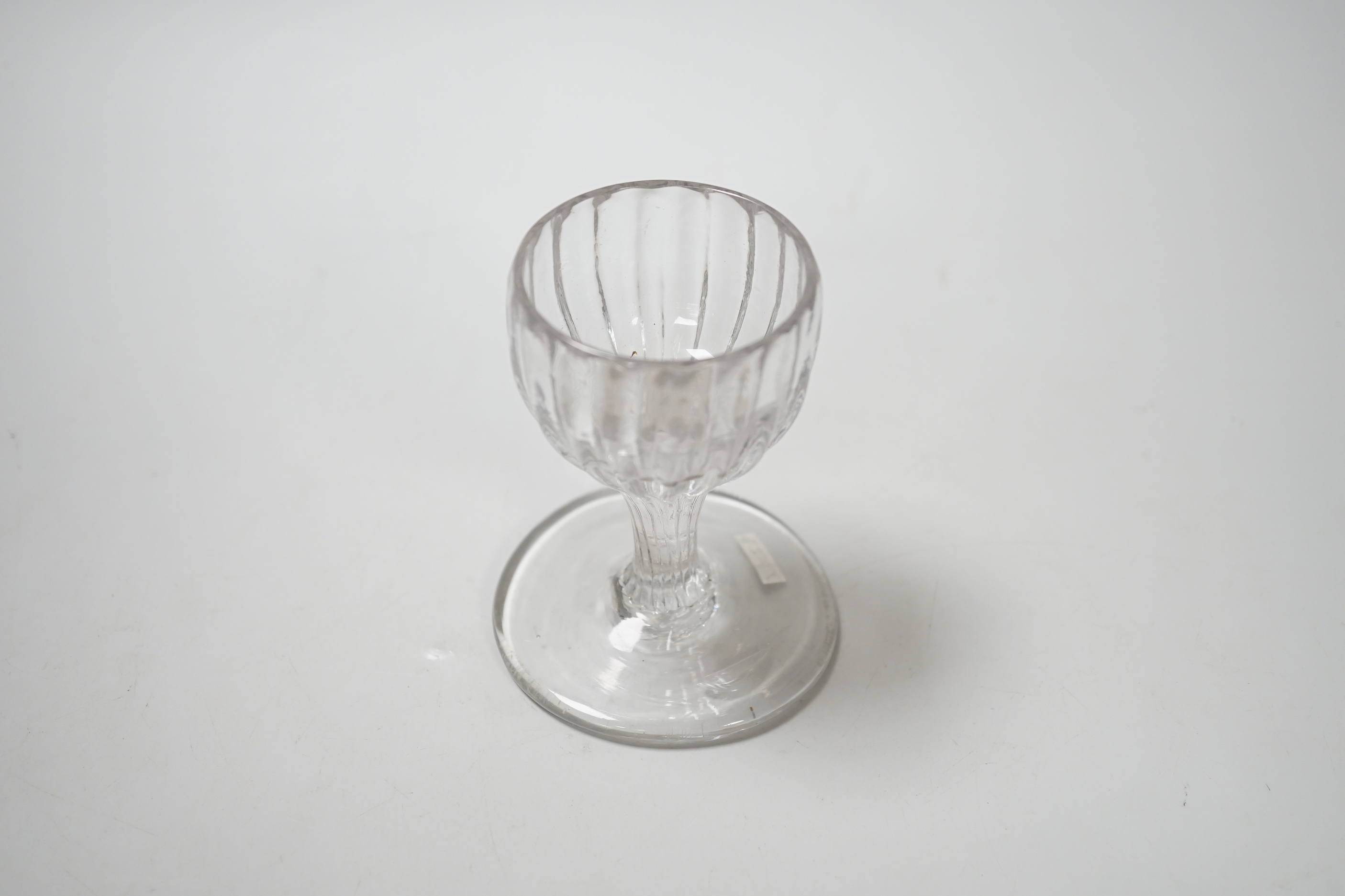 An English lead crystal dram, mid 18th century, with rib moulded bowl / stem, this rare drawn trumpet and moulded form sitting on a wide base, possibly for use on board ship, 9.5cm high